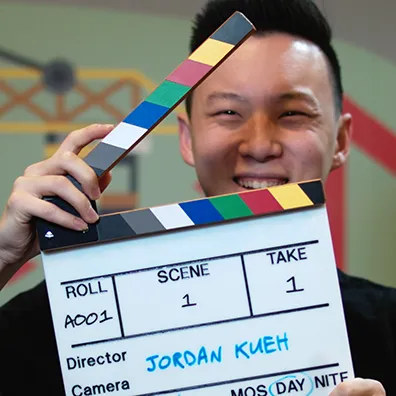 Jordan, holding a film slate (clapper board)